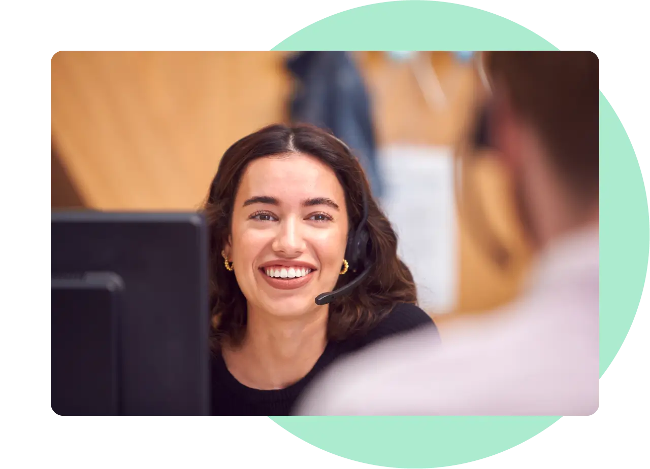 Female call centre working smiling face on at her colleague.