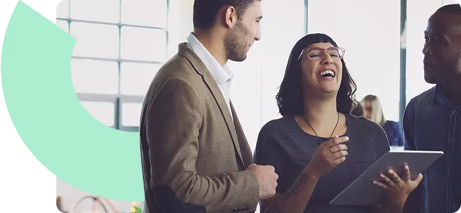 A woman laughing between two men. They are dressed in business clothing but look relaxed.